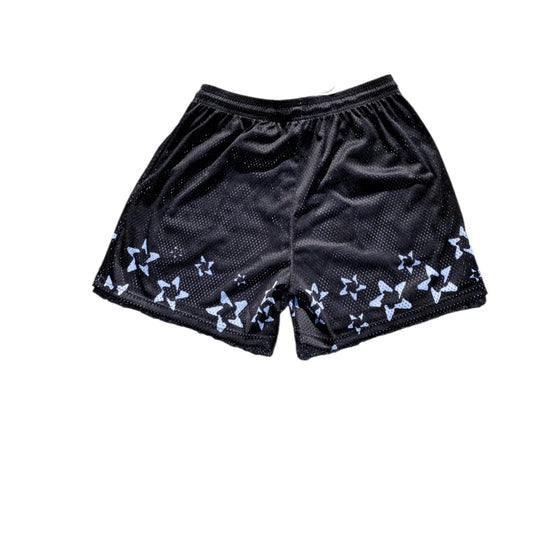 Studio product shot of the back of black basketball shorts featuring a white star pattern at the hem