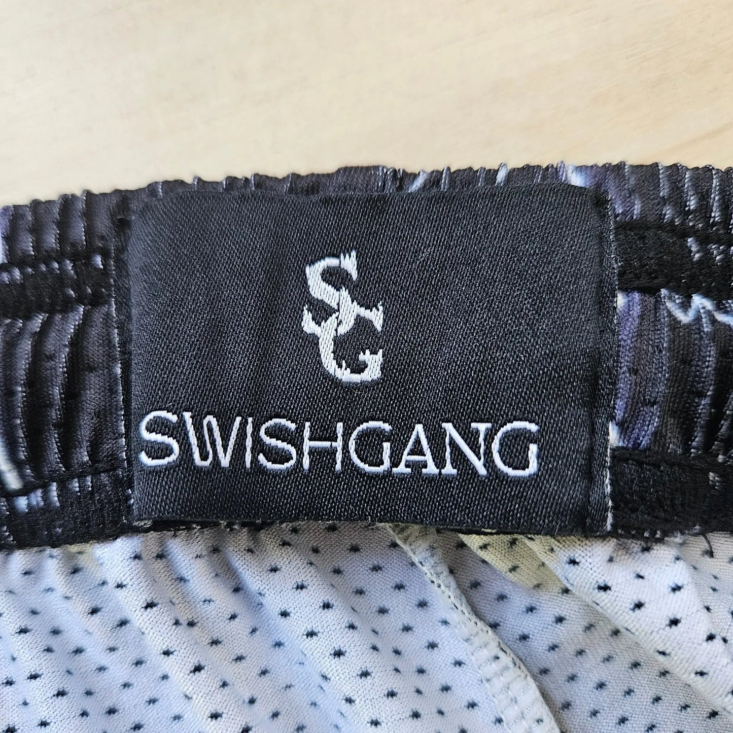 Close-up of the SwishGang brand tag inside the waistband of the lightning-print basketball shorts