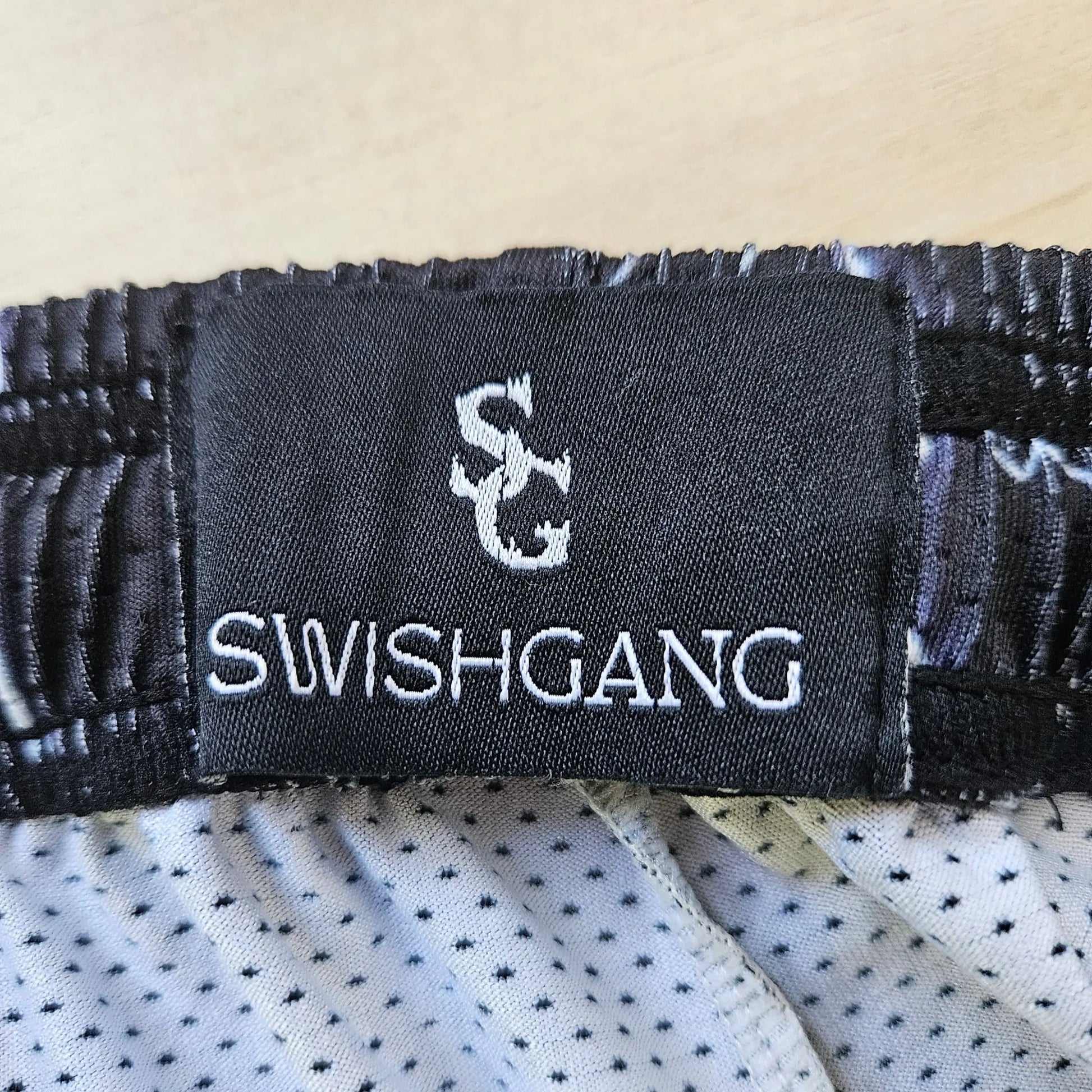 Close-up of the SwishGang brand tag inside the waistband of the lightning-print basketball shorts