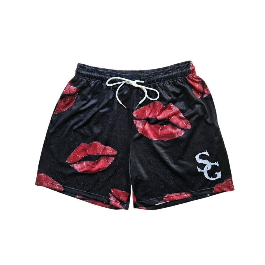Studio product shot of black basketball shorts featuring a red lip/kiss pattern and logo on the left leg