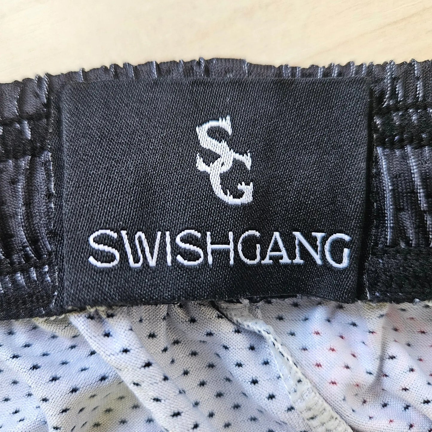 Close-up of the SwishGang brand tag inside the waistband of the rose-print basketball shorts