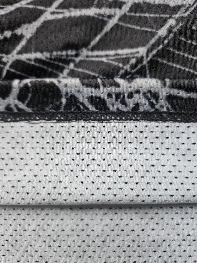 Single-layer mesh fabric detail showing spider print outer layer and breathable liner 