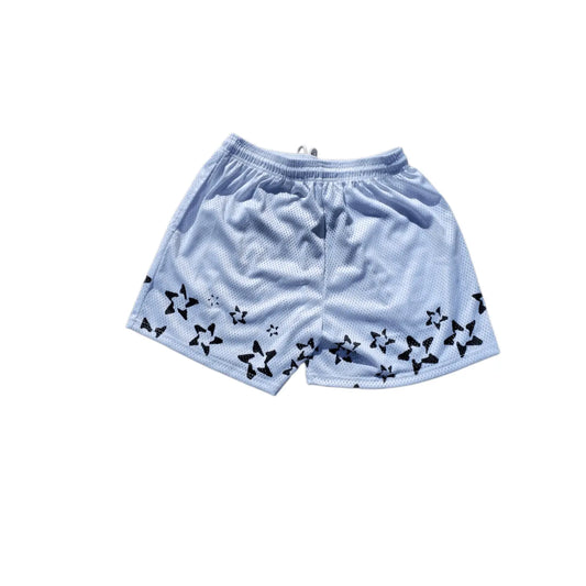 Studio product shot of the back of white basketball shorts featuring a black star pattern at the hem